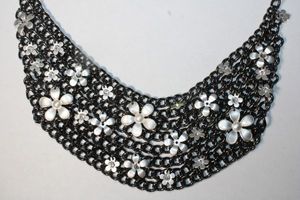 lot 236 image: Black industrial chain mesh bib style necklace with stamped aluminum flowers. Lobster clasp. 16L.