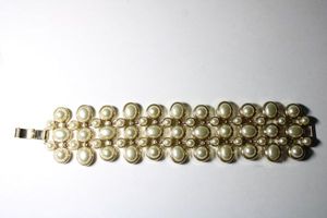 lot 239 image: Signed Banana Republic faux pearl flexible wide bracelet. Fold over clasp. Marked BR on reverse. 7L