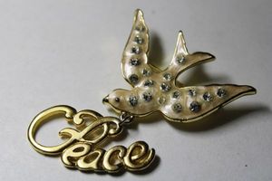 lot 268 image: Signed Danecraft iconic enamel PEACE broochpin with enamel and crystal pave white dove with script peace dangle. Marked on reverse. 2H