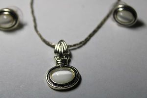 lot 286 image: Signed Roman faux Cats Eye pendant necklace and poststud earring set. Marked Roman on back of pendant and earrings. Lobster clasp. 16L