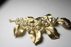 lot 302 image: Signed Crown Trifari (mark used 1955-1969) oversized large scale pearl brooch in leaf for. Measures a whopping 4.5L x 2.5H. Marked Trifari with crown on reverse.