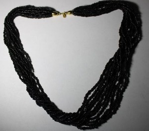lot 303 image: Signed Trifari torsade style black beaded necklace with gold tone end caps. Has Trifari hang tag. 20L. Spring ring clasp.