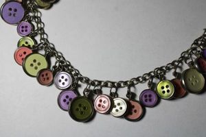 lot 314 image: Signed Zao necklace with silver framed button dangles. Has Zao hang tag. 16L