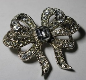 lot 333 image: Signed Monet rhinestone broochpin in bow form. Marked Monet on reverse. 2W x 2H. This mark used from 1937-mid 1950s.