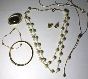 lot 99 image: Signed Monet gold tone jewelry selection. Faux pearl necklace, necklaces, bracelets, broch, poststud earrings. All marked Monet