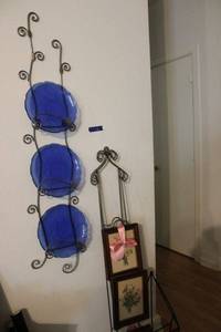 lot 116 image: Metal wall plate hangers, blue plates, and flower prints