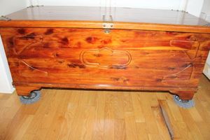 lot 26 image: Cedar Chest with wheels plus blankets and afghans. Chest measures Approx. 45.5x20x19.5 Sticker from Oscar Short Cedar Chests Nashville