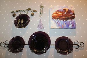 lot 56 image: Metal wall plate holders with purple plates, plus canvas art.