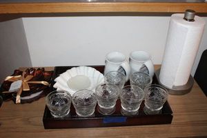 lot 91 image: Wooden tray with glassware, shell dishes, mugs, leaf plates and paper towel holder
