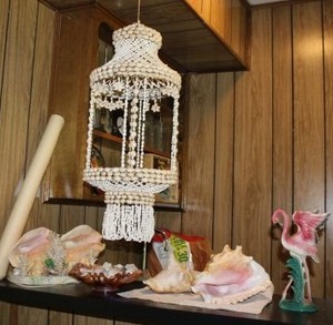 lot 85 image: Seashell Lot Shell lamp, conch shells, hanging shell decoration, flamingo figurine, Nautical poster, and shells