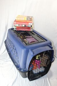 lot 158 image: Medium Sized Pet Carrier Full of Toys and Book that are All About Dogs