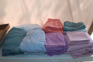 lot 199 image: Full size sheets.pink, purple, and orange w pineapple. Complete sets Teal,Blue and white w circles. All fitted w 8 coordinating pillow cases