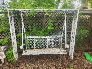 lot 213 image: Large wrought iron ornate-decorative swing and stand - will need tools to remove braces from wood fence