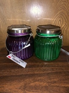 lot 173 image: 2 FG solar glass jars - 1 green and 1 purple