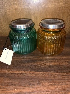 lot 175 image: 2 solar light glass jars - 1 orange and 1 green