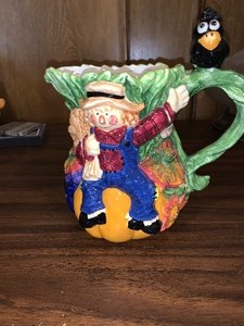 lot 200 image: Ceramic decorative scarecrow pitcher - very colorful - with crow on handle
