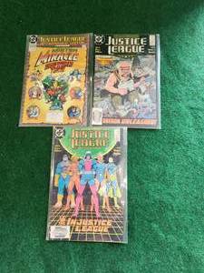 lot 18 image: Justice League - selection of 3 DC comics - Internation Special #1, International #22, and #23 - in plastic sleeves