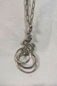 lot 9 image: Signed Coldwater Creek hammered disc pendant on 32L paper link style textured necklace. Has Coldwater Creek hang tag. Lobster clasp.