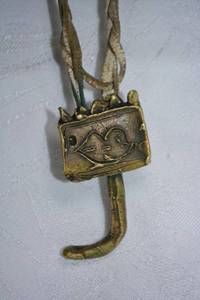 lot 23 image: Artisan crafted unusual vintage brass folk art J-pendant with hand etched face. Leather twist cord necklace (has cracking). 26L