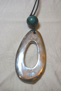 lot 37 image: Large modernist silver metal ovoid pendant with blueblack painted station bead on corded necklace. 30L. Pendant 3L