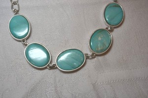 lot 47 image: Reversible oval disc station modernist necklace. Blue glass or shell on one side and hammered oval discs on reverse. 16L with 2 extender. One blue disc has white spot. Not sure if loss to finish or natural process. See photos. Lobster clasp.