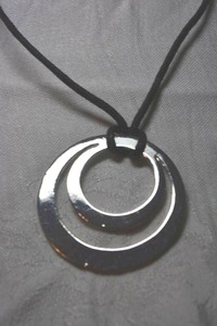 lot 52 image: Concentric circle modernist reversible pendant on adjustable corded necklace. Smooth on one side, hammered look on reverse. 36L