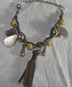 lot 63 image: Bohemian style bracelet with hammered tear drop, bead and leather dangles. Lobster clasp. Adjustable from 7-9L.
