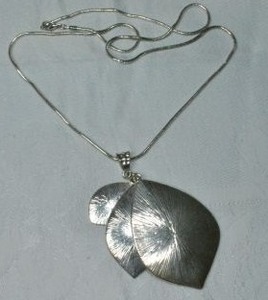 lot 75 image: Modernist hammered nested tri level pendant in leaf form with large hammered bale on 24L snake flexible necklace. Lobster clasp.