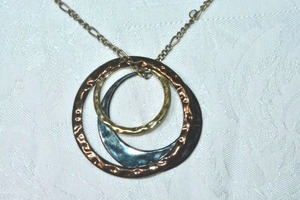 lot 76 image: Tri colored hammered modernist open disc pendant on 20L necklace. Lobster clasp.