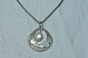 lot 85 image: Modernist hammered dancing dangle round disc pendant on 18L snake chain necklace. Lobster clasp.
