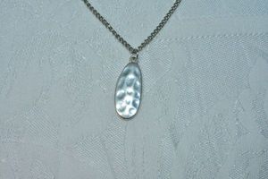 lot 87 image: Modernist hammered oval pendant on 18L necklace