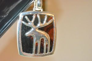lot 92 image: Modernist MCM oversized iconic moose figure pendant necklace. On midnight black ground. Oversized bale. 26L necklace with barrel clasp. Pendant 3L x 2W