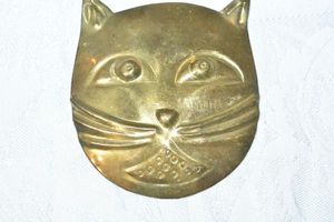 lot 93 image: Brass colored MCM large metal cat face broochpin with older style tube clasp. 3H x 2.75W