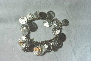 lot 110 image: Heavy metal hammered disc dangle stretch bracelet featuring 2 sizes of discs.