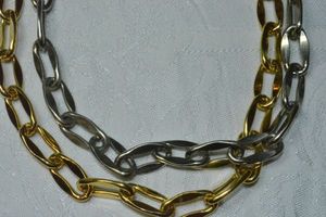 lot 126 image: Silver and gold polished large link industrial heavy double necklace strands on a single gold tone chain. 34L. Double shepherds crook clasp.