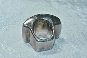 lot 127 image: Modernist exaggerated ring with large table. Acrylic made to look like silver. Size 7. Minor use scratches.