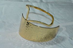 lot 135 image: Modernist gold tone cuff bracelet with hammered top and by pass design. Top about 2W