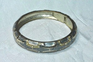 lot 149 image: Industrial  modernist grey enamel and gold tone hinged bangle bracelet.