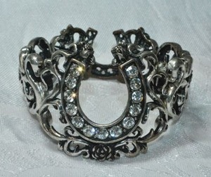 lot 152 image: Exaggerated scroll and rose link stretch bracelet with crystal decorated horseshoe top.