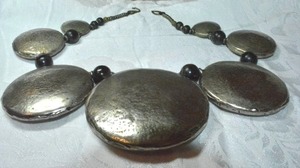 lot 153 image: MCM Industrial tribal style exaggerated graduated hollow disc statement necklace with black ball bead separators. Fish hook clasp. One disc has dents. Very 1970s style.
