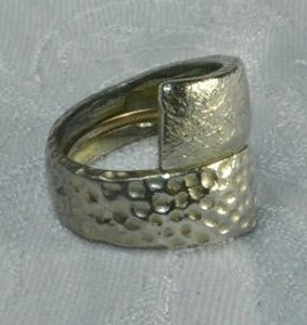 lot 177 image: Signed Chicos modernist style bypass ring with hammered design. Size 7.5. Marked Chicos inside. Has interior snug adjust fitting.