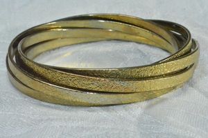 lot 190 image: Modernist interconnected (6) bangle bracelet with brushed texture and gold finish.