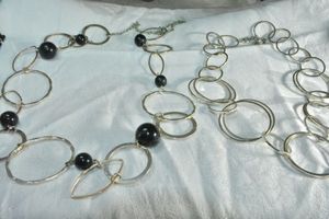 lot 192 image: (2) Modernist disc necklaces with matte and polished textured links (one with black bead stations). 34L and 16L with 3 extender.