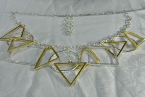 lot 196 image: Signed modernist cable chain two tone gold and silver finish necklace with geometric dangle pendants. Has M with infinity hang tag. Hook clasp. 24L