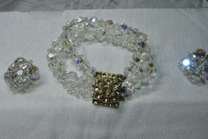 lot 241 image: Faceted AB glass crystal 3-strand bracelet with decorated hidden box clasp 7L and clip earrings.