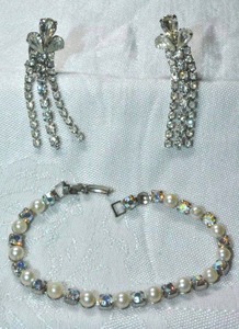 lot 242 image: Glass AB rhinestone and faux pearl tennis bracelet with fold over clasp and clip dangle earrings. 7L. Earrings 2L