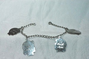 lot 262 image: Vintage sterling silver charm bracelet with figural charms. Bracelet and all 4 charms marked sterling. Has personalization.