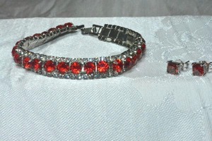lot 279 image: Red and clear rhinestone bracelet and poststud earrings. 7L Fold over clasp.