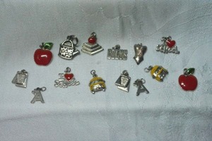lot 280 image: Teacher themed enamel charms. Includes homework, yellow school bus, red apple, I Love Teaching A