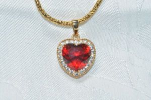 lot 283 image: Signed Kuniu rhinestone halo heart shape bling pendant on fancy textured 16L necklace. Lobster clasp. Marked Kunio on bale